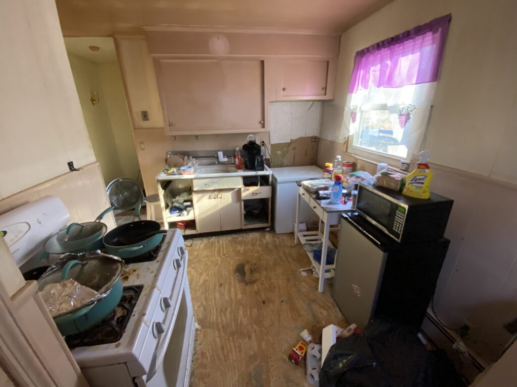 A photo of a kitchen in a bad condition.