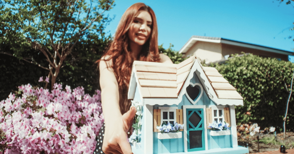 Woman holding a tiny doll house as an inspiration that you can sell your house fast in NJ